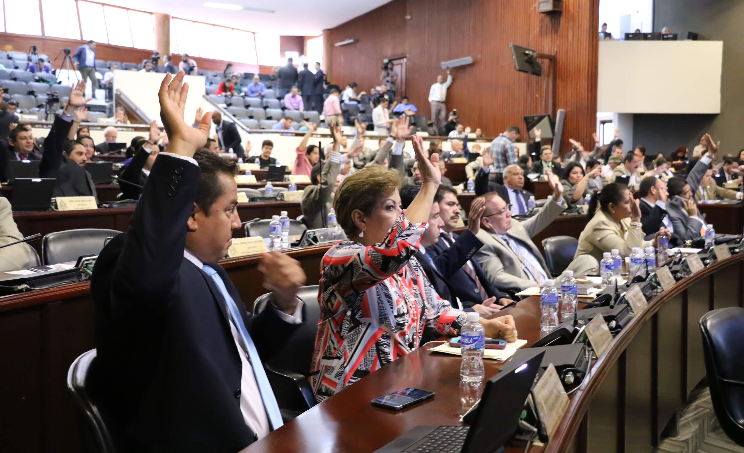 Several people raise their hands in the Honduran National Congress